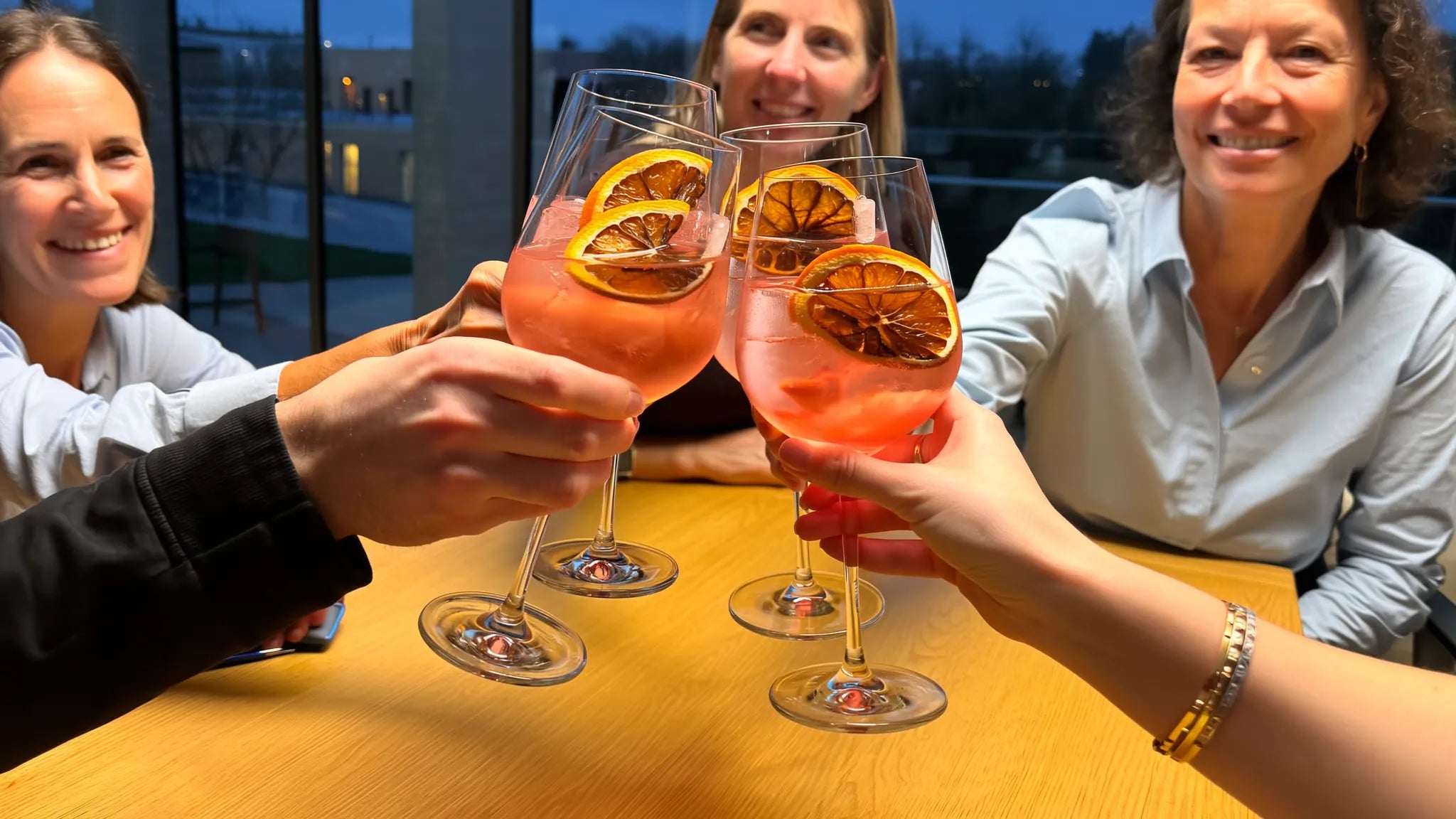 Vier identische Gläser Sankt Sprizz beim Anstoßen — von außen sieht keiner, welche Stärke im Glas ist (Symbolbild)
